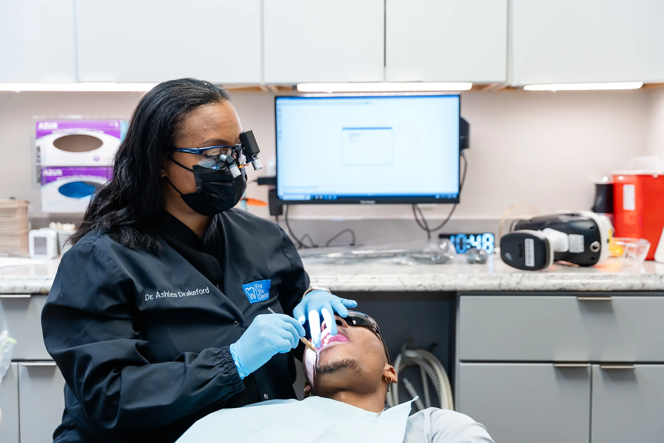 Dr. Drakeford giving a patient a dental exam at For You Dental in Carrollton, TX