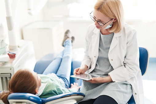 Dentist assessing a patient needing TMJ treatment at For You Dental in Carrollton, TX